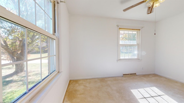 empty room featuring light colored carpet and ceiling fan