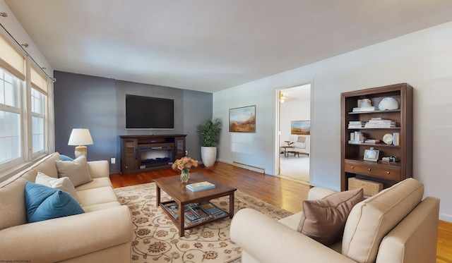 living room featuring baseboard heating and light hardwood / wood-style flooring