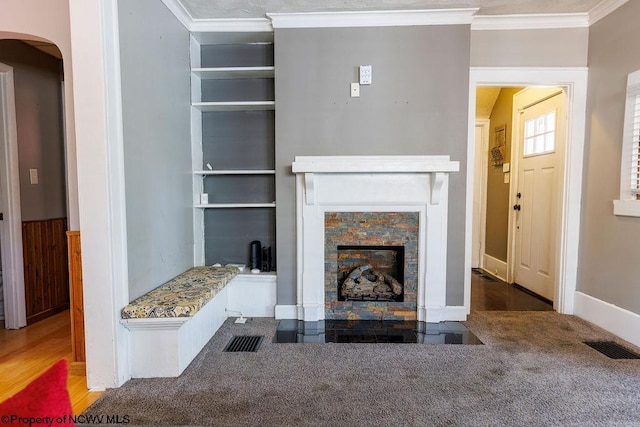 unfurnished living room featuring crown molding, dark wood-type flooring, and a fireplace