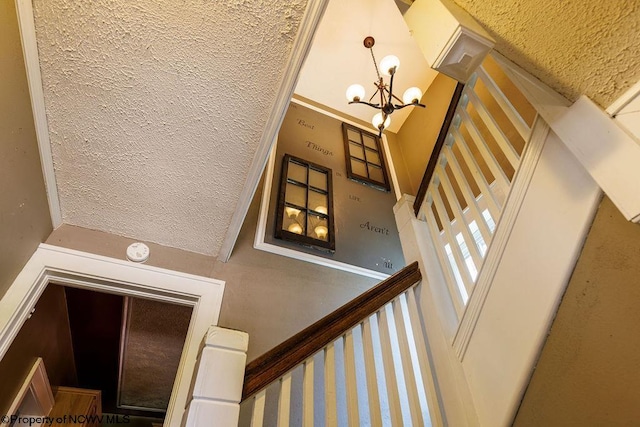 stairs featuring a notable chandelier and a towering ceiling