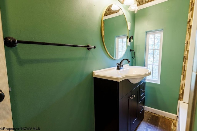 bathroom with vanity, crown molding, and hardwood / wood-style flooring