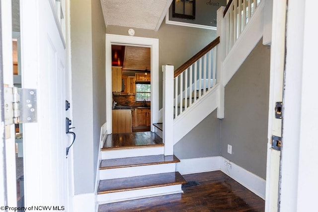 staircase featuring hardwood / wood-style flooring and a textured ceiling