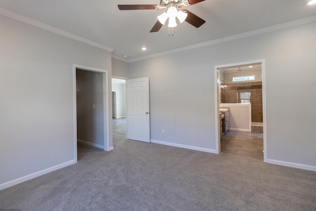 unfurnished bedroom with crown molding, ensuite bathroom, carpet floors, and ceiling fan