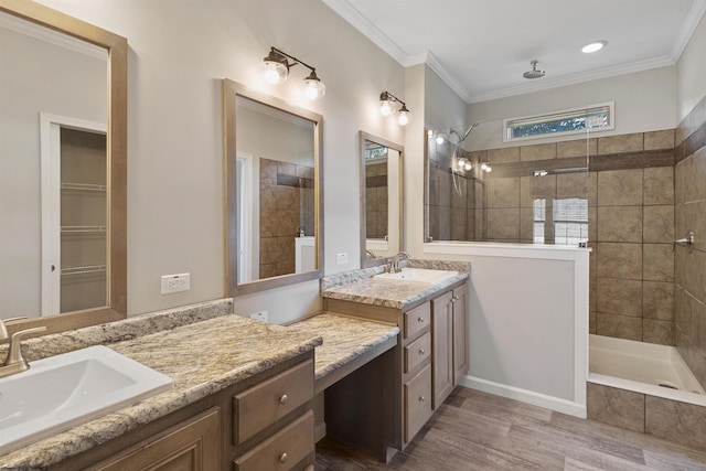 bathroom featuring vanity, crown molding, hardwood / wood-style flooring, and tiled shower