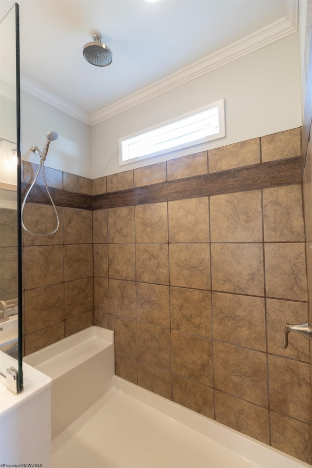full bathroom with a tile shower and ornamental molding