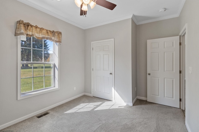 unfurnished bedroom featuring ornamental molding, light colored carpet, and ceiling fan