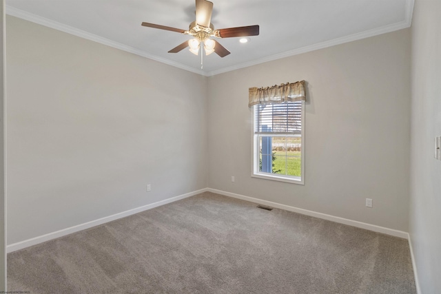 carpeted spare room featuring ornamental molding, a ceiling fan, visible vents, and baseboards