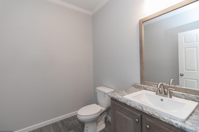 bathroom featuring toilet, hardwood / wood-style floors, vanity, and ornamental molding