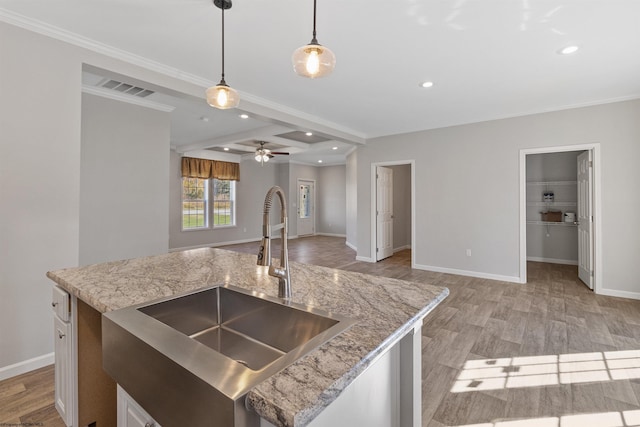 kitchen featuring beamed ceiling, light hardwood / wood-style flooring, sink, and hanging light fixtures