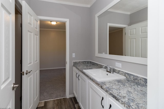 bathroom with vanity, crown molding, and hardwood / wood-style flooring