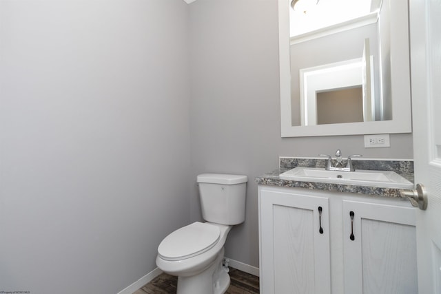 bathroom featuring vanity, hardwood / wood-style flooring, and toilet