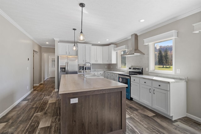 kitchen featuring a kitchen island with sink, white cabinetry, wall chimney range hood, and stainless steel appliances