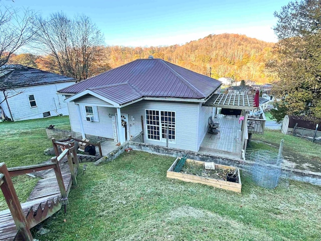 back of property featuring a mountain view and a yard