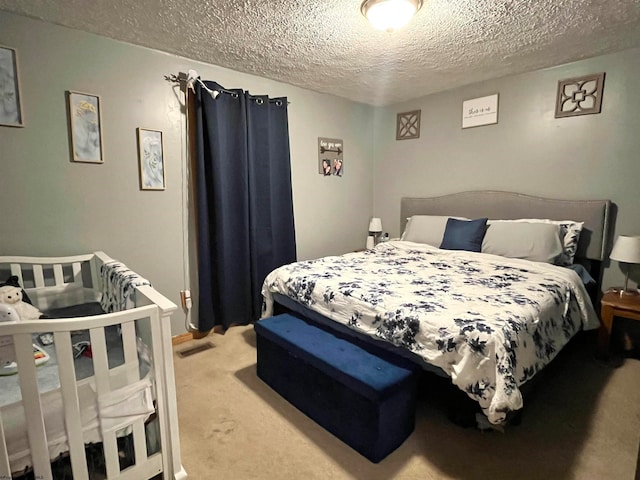 bedroom featuring light colored carpet and a textured ceiling