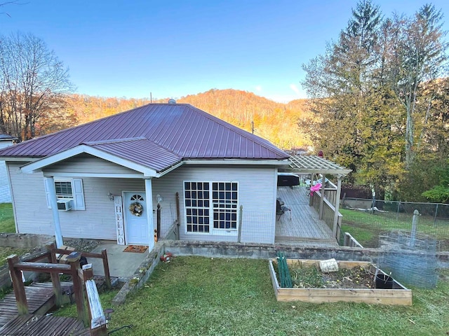 view of front facade with cooling unit, a mountain view, and a front lawn