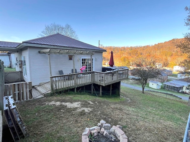 rear view of property with a deck and a lawn