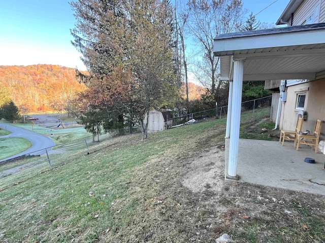 view of yard with a mountain view, a storage unit, and a patio area