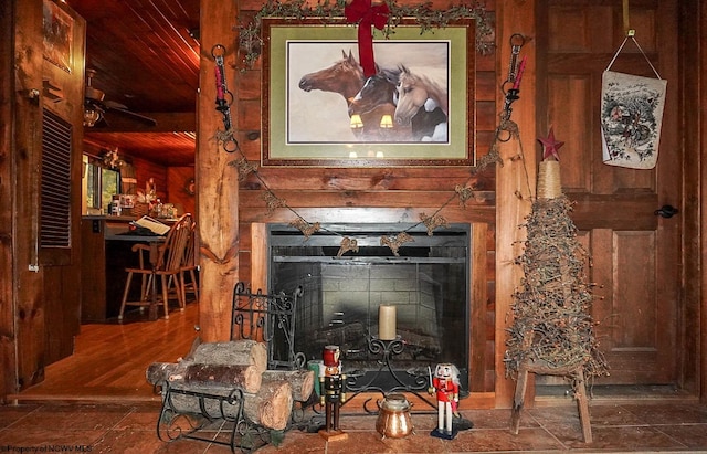 room details with wood walls, tile patterned flooring, and a fireplace