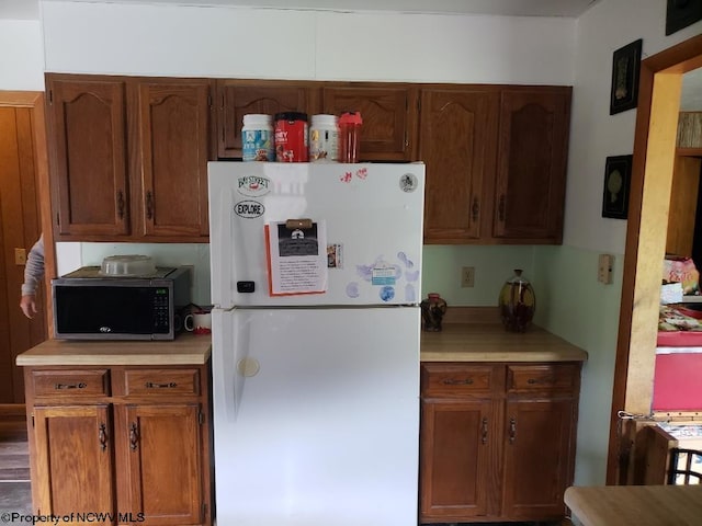 kitchen with hardwood / wood-style floors and white fridge