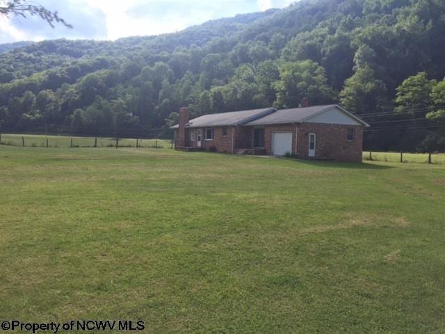 view of yard with a rural view and a mountain view