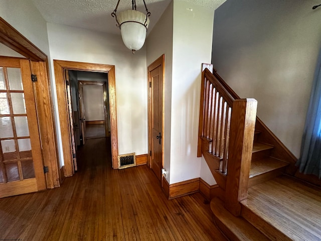 stairway featuring hardwood / wood-style floors and a textured ceiling