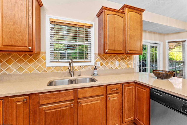 kitchen featuring decorative backsplash, stainless steel dishwasher, and sink