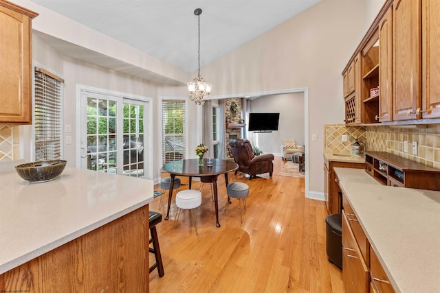 dining space with light hardwood / wood-style floors, a notable chandelier, and lofted ceiling