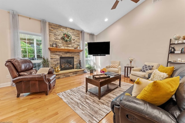 living room featuring light hardwood / wood-style floors, a fireplace, plenty of natural light, and ceiling fan