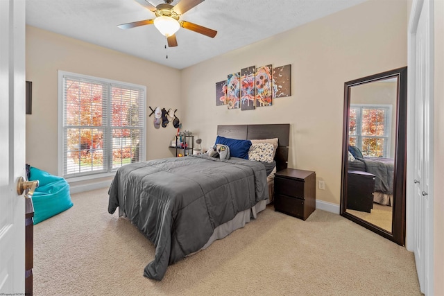 bedroom featuring light colored carpet and ceiling fan