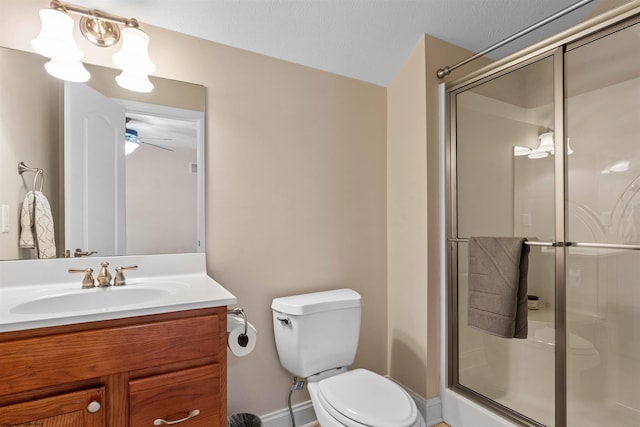 bathroom featuring toilet, a shower with shower door, vanity, a textured ceiling, and ceiling fan