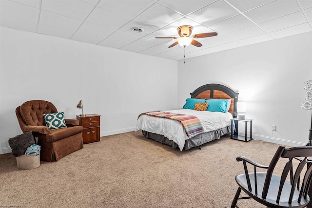 carpeted bedroom with ceiling fan and a paneled ceiling