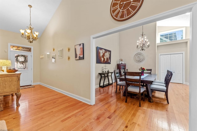 dining room featuring hardwood / wood-style floors, high vaulted ceiling, and a chandelier