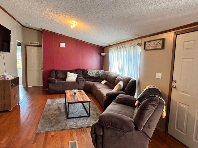 living room with dark wood-type flooring, a textured ceiling, and ornamental molding