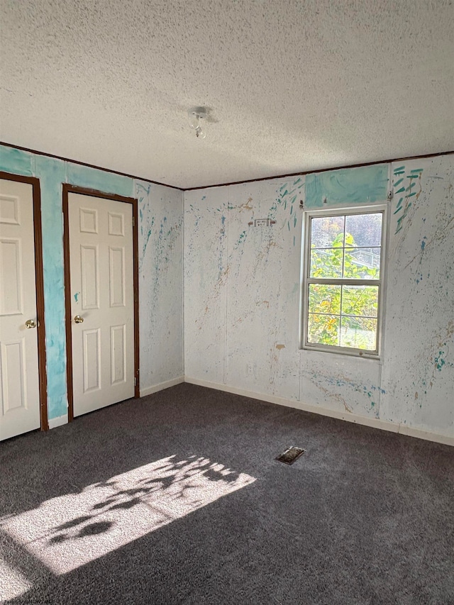 carpeted spare room featuring a textured ceiling