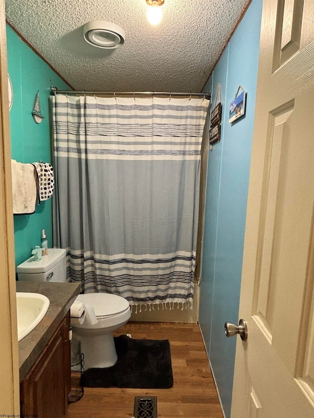 bathroom featuring a textured ceiling, a shower with shower curtain, toilet, vanity, and hardwood / wood-style flooring