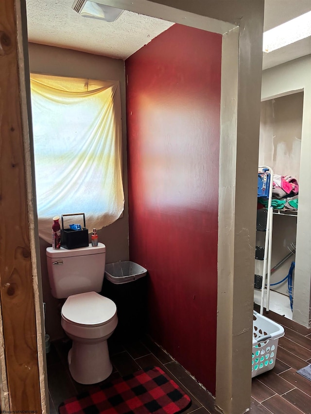 bathroom with toilet, hardwood / wood-style floors, and a textured ceiling