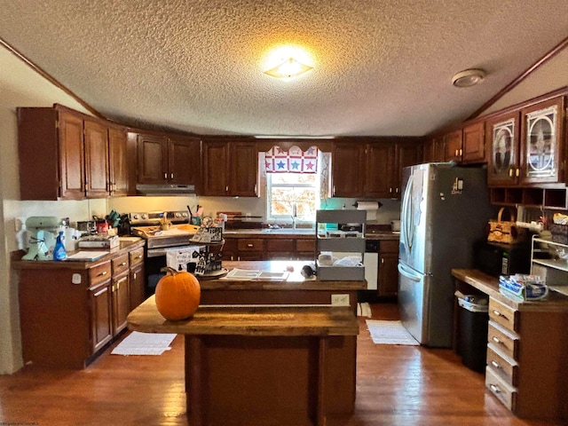 kitchen featuring a center island, appliances with stainless steel finishes, a textured ceiling, and extractor fan