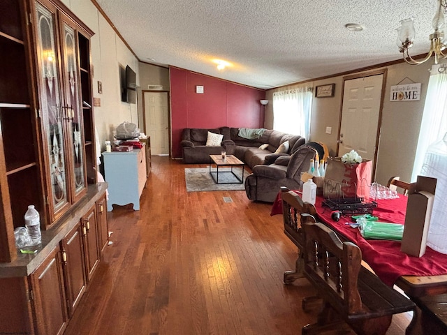 dining room with dark wood-type flooring, crown molding, a textured ceiling, and lofted ceiling