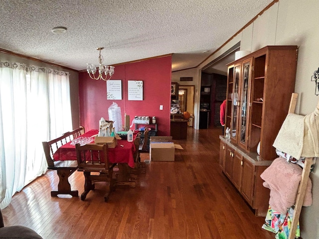 dining room with ornamental molding, dark hardwood / wood-style floors, a textured ceiling, and vaulted ceiling