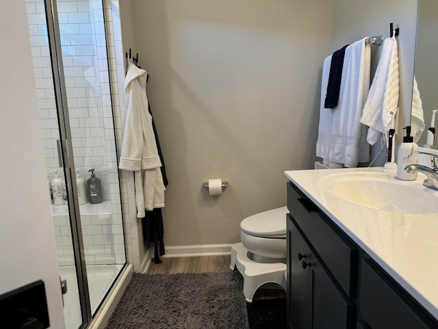 bathroom with vanity, walk in shower, toilet, and wood-type flooring