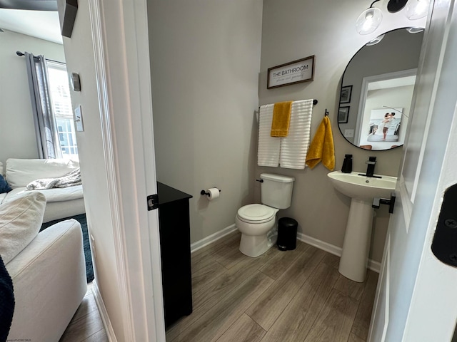 bathroom with toilet and hardwood / wood-style floors