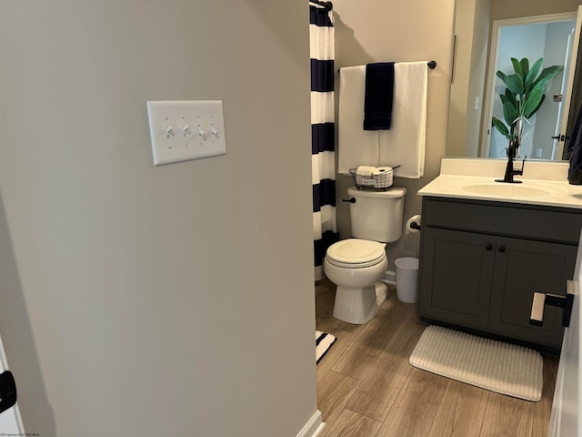 bathroom with vanity, toilet, and hardwood / wood-style flooring