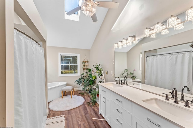 bathroom featuring a ceiling fan, a sink, double vanity, and wood finished floors