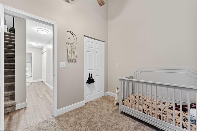 carpeted bedroom with a nursery area and baseboards