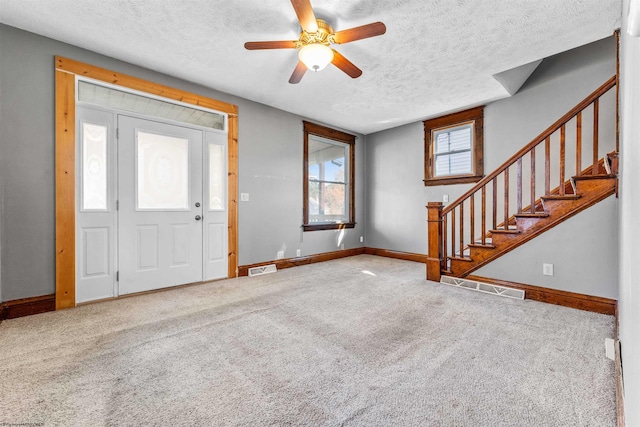 carpeted entryway with a textured ceiling and ceiling fan