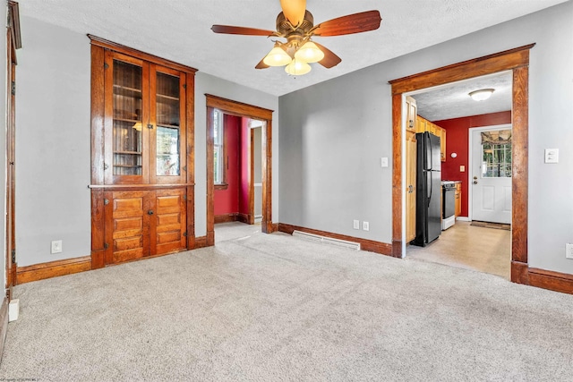 carpeted spare room with a textured ceiling and ceiling fan