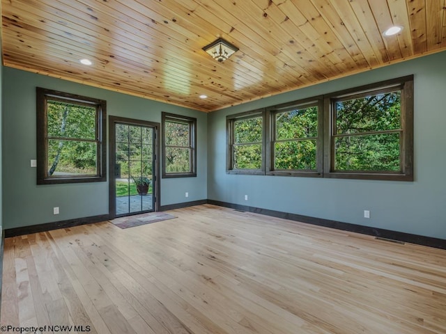 empty room with light hardwood / wood-style floors, crown molding, wood ceiling, and plenty of natural light