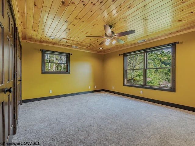 empty room with ornamental molding, wood ceiling, carpet floors, and ceiling fan