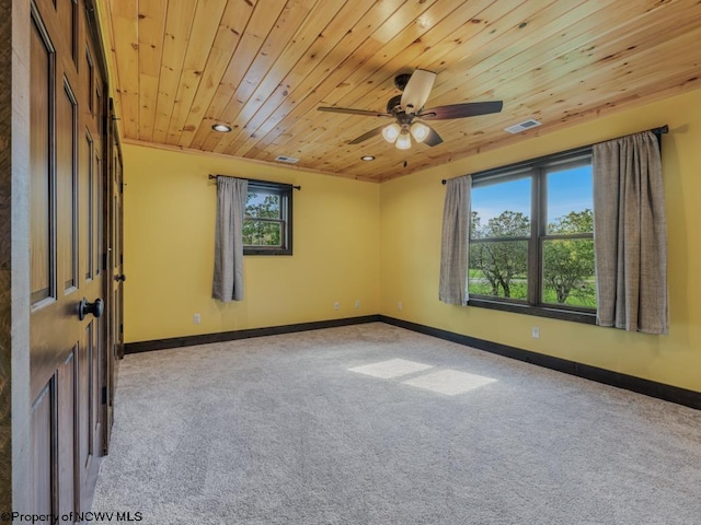 carpeted spare room with ceiling fan and wooden ceiling