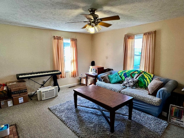 living room with ceiling fan, a textured ceiling, carpet, and a wealth of natural light